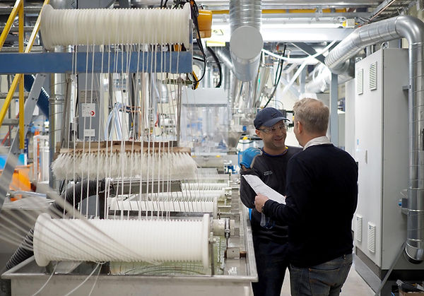 Kollegor vid extruder i Polykemis produktion i Ystad