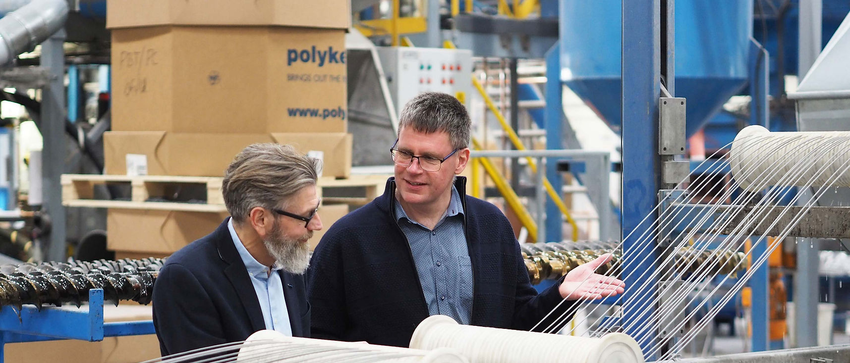 Tekniker och säljare vid en aktiv extruder i Polykemis produktion